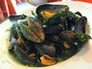 Mussels in a white wine reduction with pesto sauce